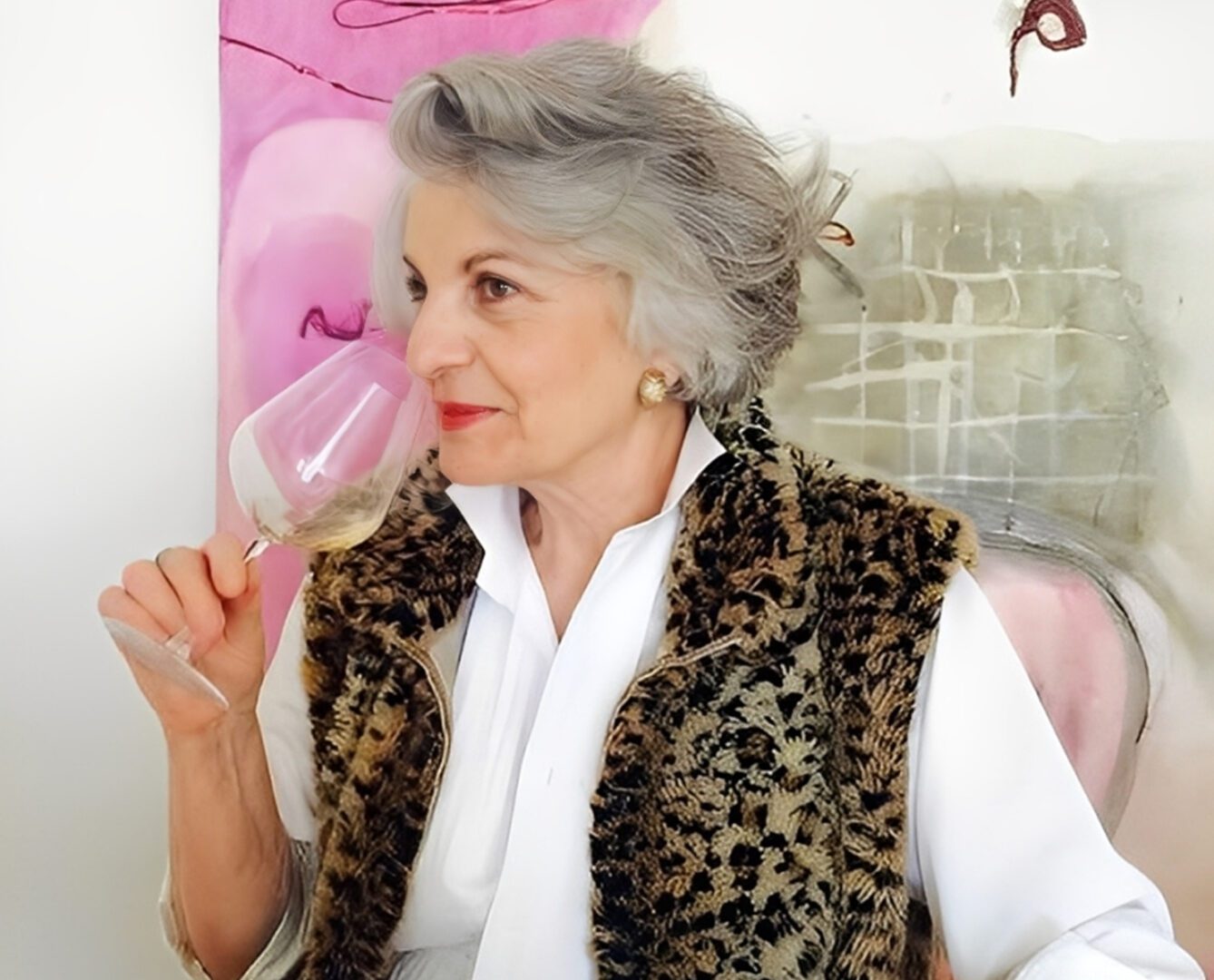 Woman sipping wine by colorful artwork